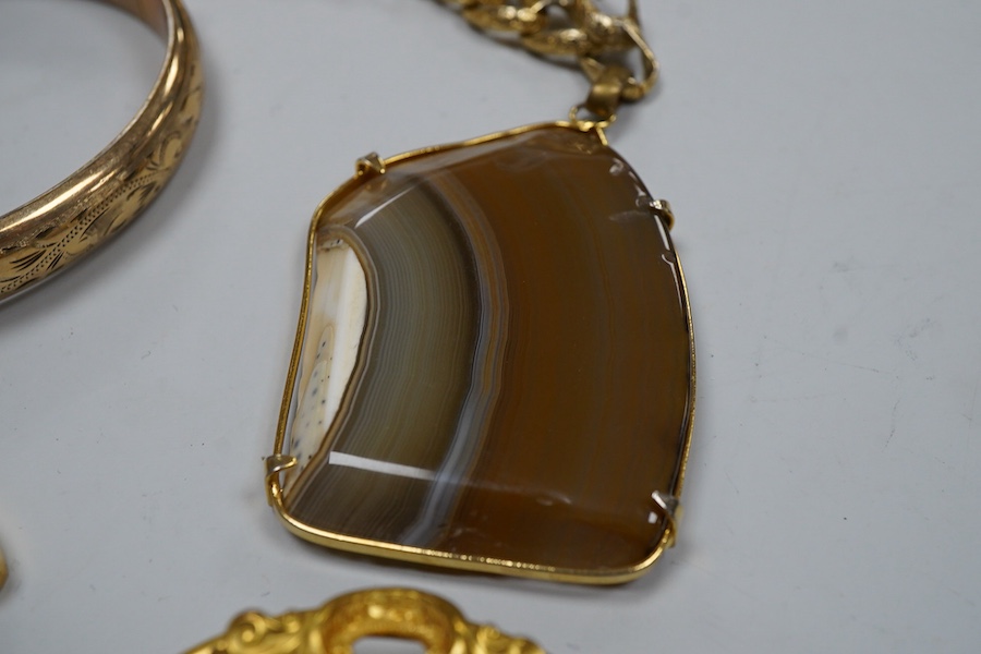 A group of gilt metal / pinchbeck jewels and an Arts & Crafts brooch by William Hair Haseler, comprising: a hinged bangle; an enamelled pendant in the Egyptian revival style; a gold curb link bracelet with a heart-shaped